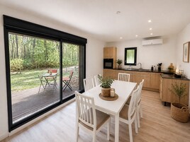 Cozinha moderna com armários de madeira, forno embutido e janela com vista para um jardim.