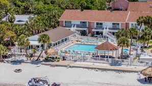 A resort with a swimming pool, lounge chairs, and a beach area. - Your own Tropical Resort Heated Pool Pickleball (St. Petersburg)