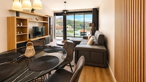 En moderne stue med spiseområde, sofa og fjernsyn.