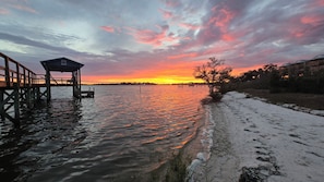 A waterfront view with a wooden dock and a small shelter. - Windswept Cottage - private pier and beach access (Cedar Key)