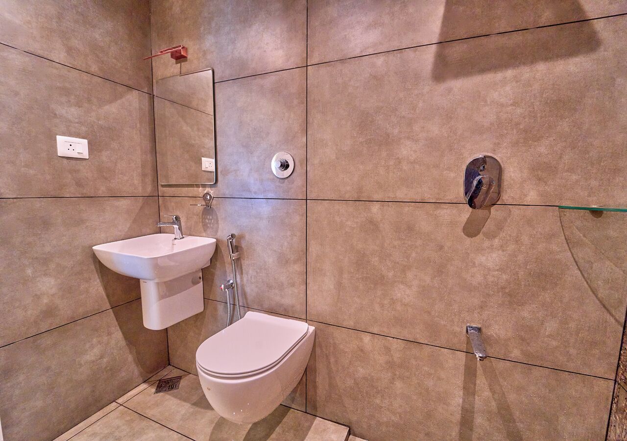 A bathroom with a toilet, sink, and shower.