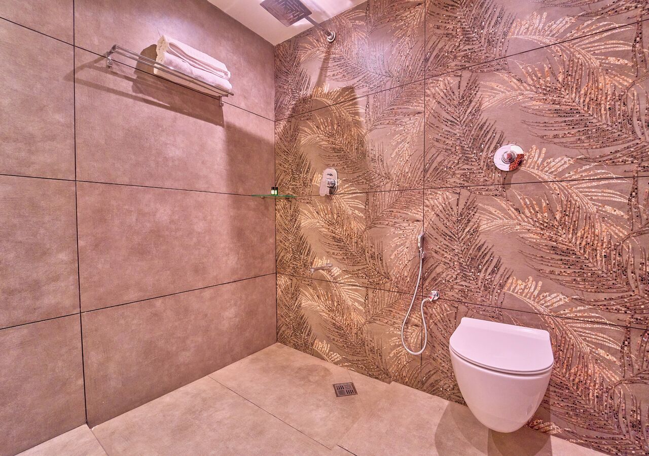 A bathroom with a shower, toilet, and towel rack.