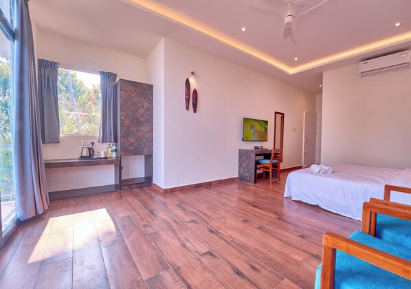 A spacious room with a bed, a desk, and a chair. - Jose Villa Kanthalloor by VOYE HOMES (Devikolam)