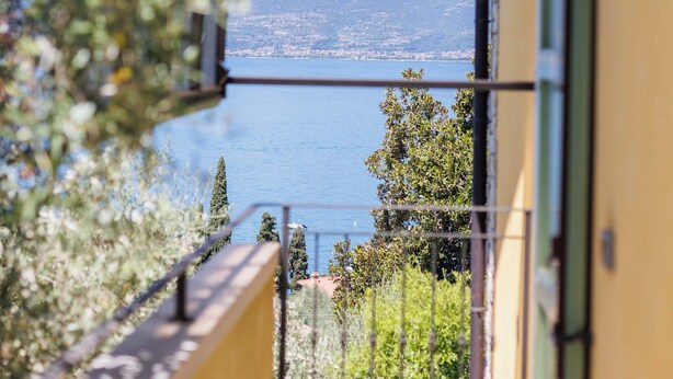 A balcony with a view of a lake and mountains. - Jordan House (Torri del Benaco)