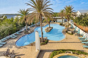 A pool area with lounge chairs, palm trees, and a view of the sea. - 1 Mi to Blue Mtn Beach! 30A Getaway w/ Golf Cart (Santa Rosa Beach)