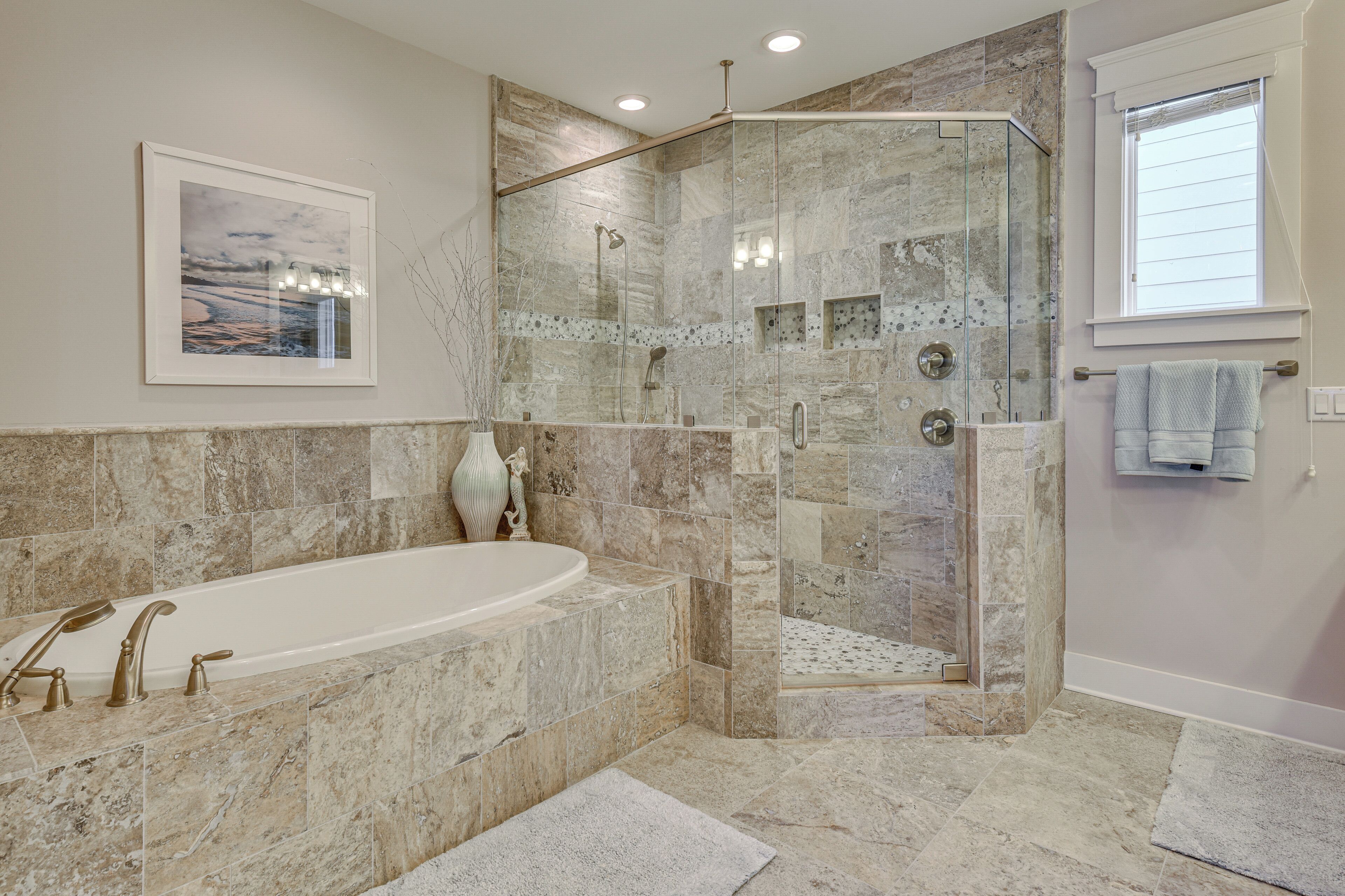 Une salle de bain moderne avec une douche à parois de verre, une baignoire sur pieds et un grand tableau encadré au mur.