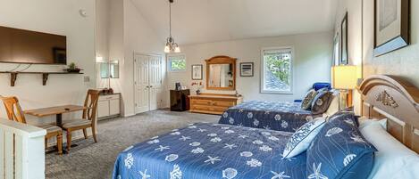 A bedroom with two beds, a desk, a chair, a dresser, a mirror, and a ceiling fan.