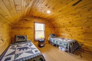A cozy cabin room with two beds, a window with blinds, a lamp, and a small table. - Butler Cabin w/ Fire Pit: 7 Mi to Doe Mtn! (Mountain City)