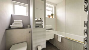 Une salle de bain moderne équipée de toilettes, d’un lavabo et d’une douche.