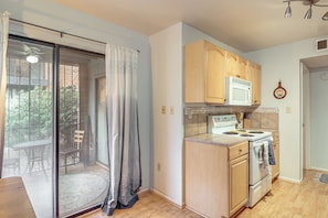 A kitchen with wooden cabinets, a microwave, and a stove. - Pool Access! Quiet Condo, 2 Mi to Reid Park (Tucson)