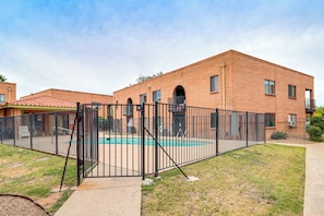 A brick building with a swimming pool, surrounded by a black metal fence. - Pool Access! Quiet Condo, 2 Mi to Reid Park (Tucson)