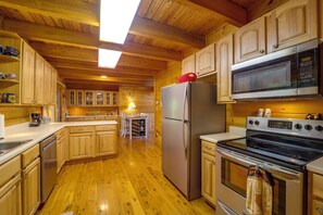 A wooden cabin kitchen with a refrigerator, microwave, stove, and wooden cabinets. - Butler Cabin w/ 2 Decks: Near Watauga Lake! (Mountain City)