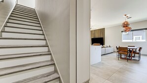 A staircase leading to a living area with a dining table and chairs. - Private Yard & Covered Patio: Modern Tampa Getaway (Tampa)