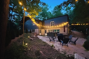 A house with a patio area, outdoor seating, and string lights.