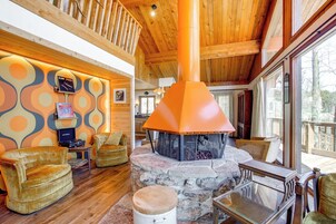 Un interior acogedor con chimenea de piedra, techo de madera y asientos cómodos.