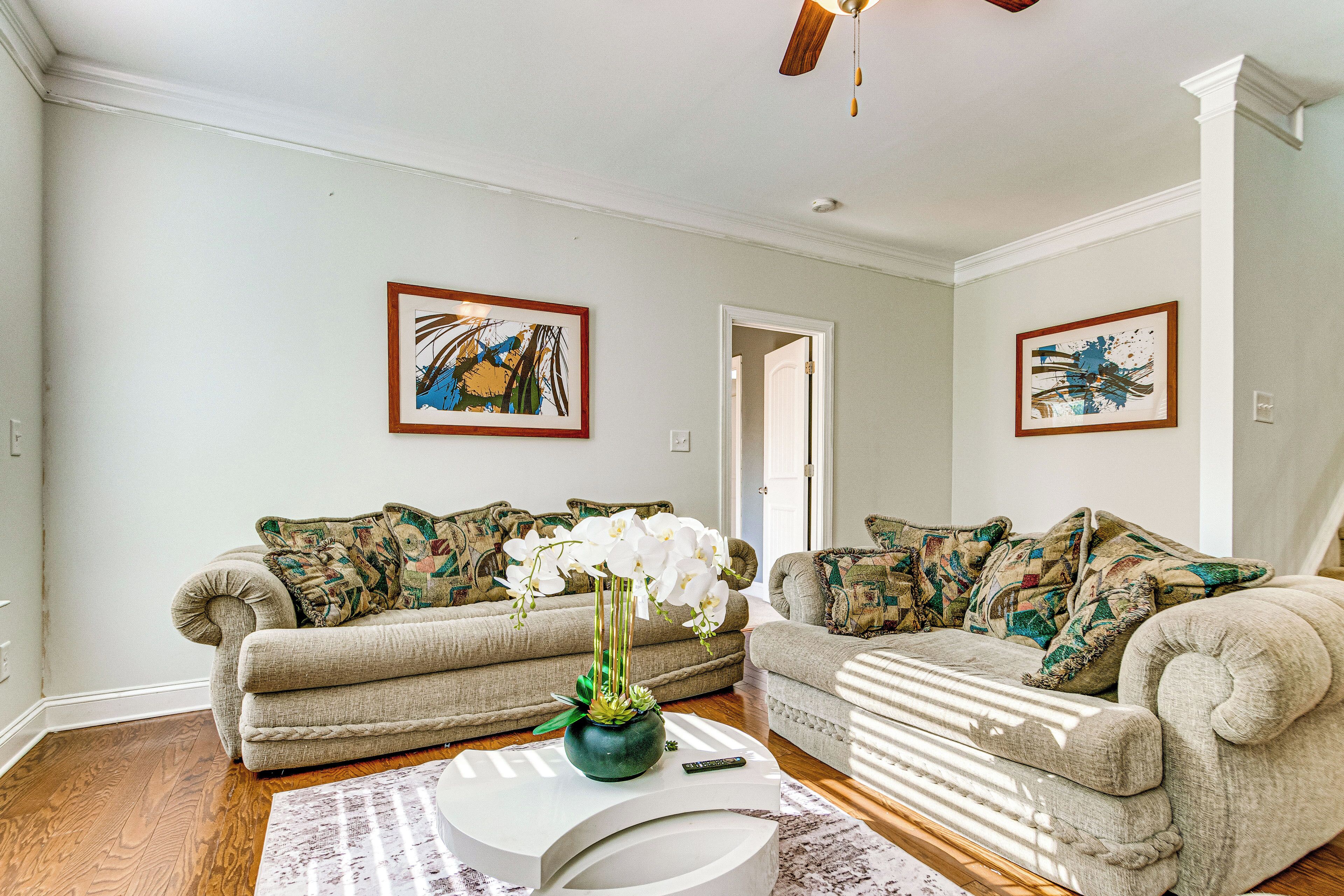 A living room with two sofas, a coffee table, and a vase with flowers.