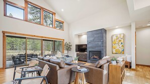 Een ruime woonkamer met een grote modulaire bank, een open haard en een televisie.