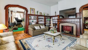 Una sala de estar con chimenea, piano, sofá y una mesa de centro.