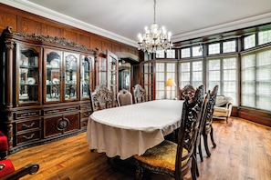 A dining room with a large wooden cabinet, ornate chairs, and a chandelier. - Historic Victorian Cottage, 1 Mi to Niagara Falls (Niagara Falls)