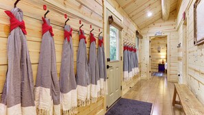 A wooden interior with a hallway, a bench, and a door leading to another room. - Ultimate River Retreat! Blanco Family Cabin (Blanco)