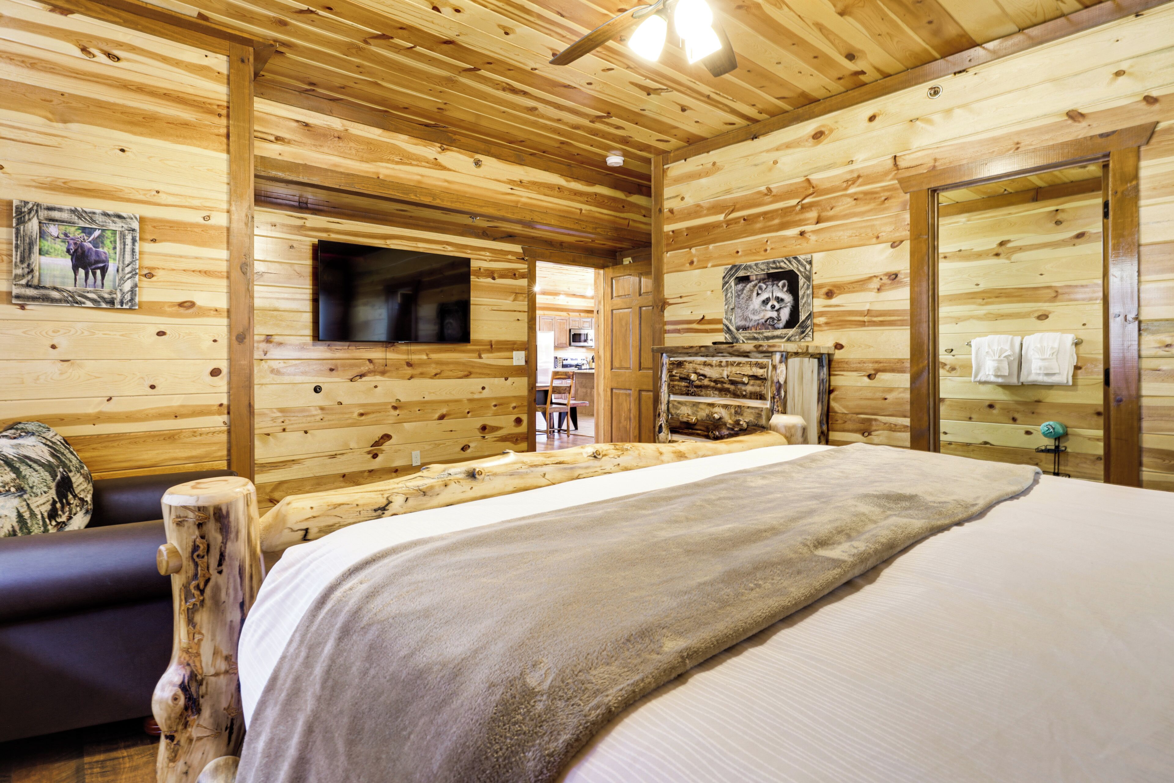 Een houten chalet met een bed, een televisie en een open haard.