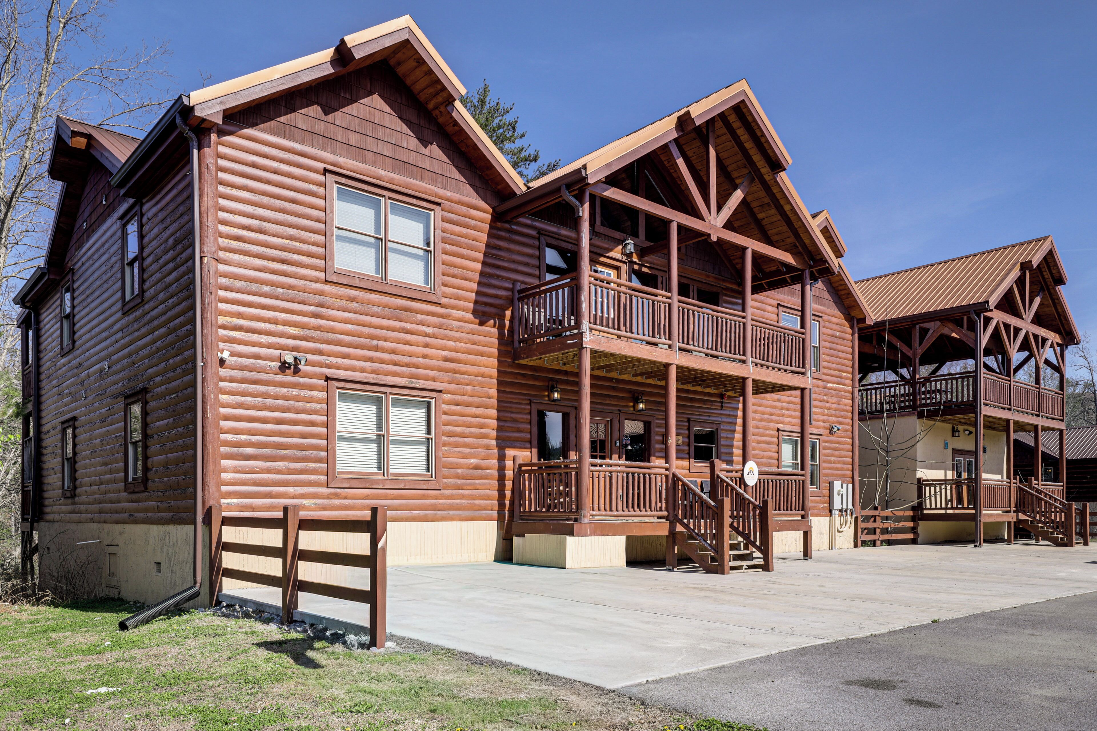 A large log cabin with a balcony, a covered porch, and a second-story balcony.