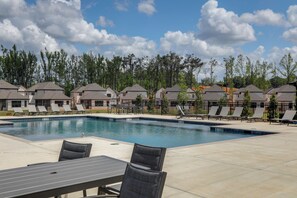 A swimming pool with lounge chairs and a table, surrounded by houses and trees. - The 5th Quarter: Ole Miss Reunions 2 Mi Away (Oxford)
