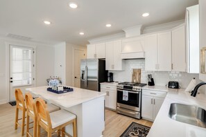 A modern kitchen with white cabinets, a stainless steel refrigerator, a gas stove, and a sink. - The 5th Quarter: Ole Miss Reunions 2 Mi Away (Oxford)