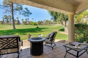 A patio with outdoor furniture, a fire pit, and a view of a golf course. - Relax Poolside! Golfer's Paradise in Palm Desert (Palm Desert)