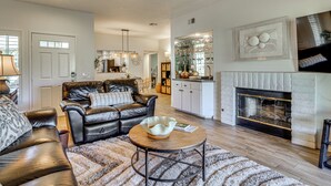 A living room with a leather sofa, a coffee table, and a fireplace. - Relax Poolside! Golfer's Paradise in Palm Desert (Palm Desert)