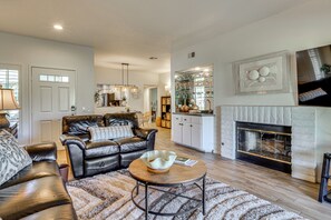 A living room with a leather sofa, a coffee table, and a fireplace. - Relax Poolside! Golfer's Paradise in Palm Desert (Palm Desert)