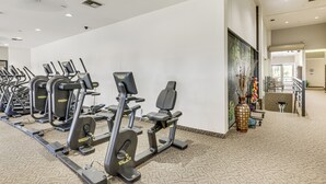 A gym with multiple exercise machines, a reception area, and a carpeted floor. - Relax Poolside! Golfer's Paradise in Palm Desert (Palm Desert)