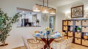 A dining area with a glass table, wicker chairs, and a potted plant. - Relax Poolside! Golfer's Paradise in Palm Desert (Palm Desert)