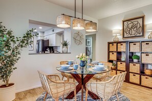 A dining area with a glass table, wicker chairs, and a potted plant. - Relax Poolside! Golfer's Paradise in Palm Desert (Palm Desert)