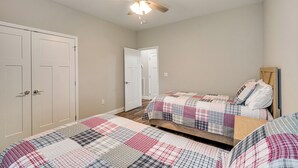 A bedroom with two beds, a ceiling fan, and a wardrobe. - Walk to Cumberland County Playhouse! Modern Home (Crossville)