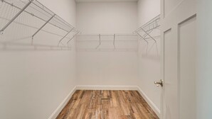 A room with a wooden floor, white walls, a door, and metal wire shelves. - Walk to Cumberland County Playhouse! Modern Home (Crossville)