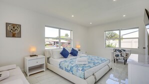 A modern bedroom with a bed, bedside tables, a desk, and a chair. - Luxe Ft Lauderdale Pool Oasis Near Airport & Beach (Fort Lauderdale)