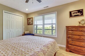 A bedroom with a bed, a dresser, a window with blinds, a ceiling fan, and a framed picture on the wall. - Rural Bybee Retreat w/ Mtn Views! (Bybee)