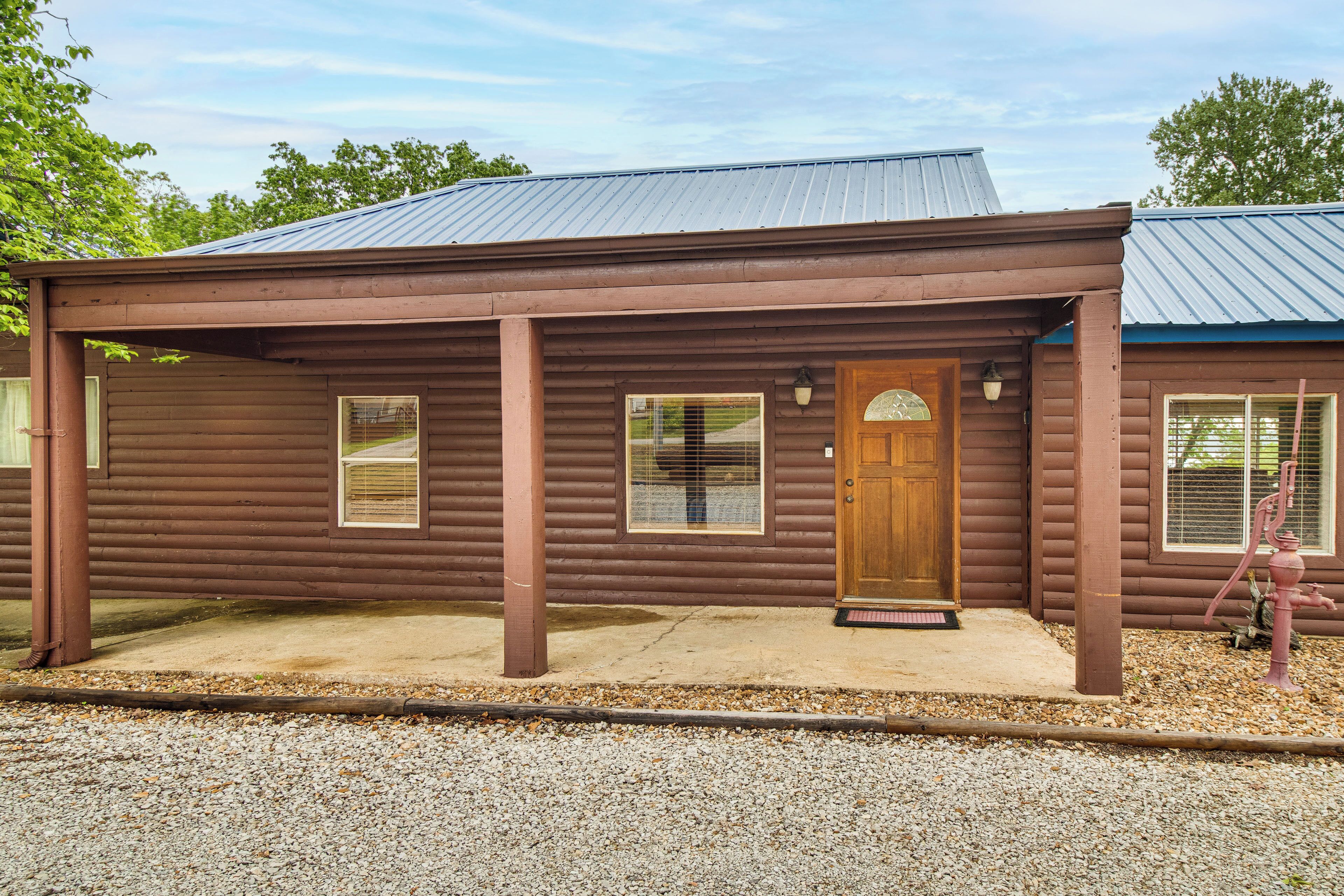 A log cabin with a porch, a wooden door, and a window.