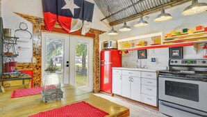 A kitchen with a red refrigerator, white cabinets, and a large stove. - Walk to Granbury Square & Beach! 'texas Cottage' (Granbury)