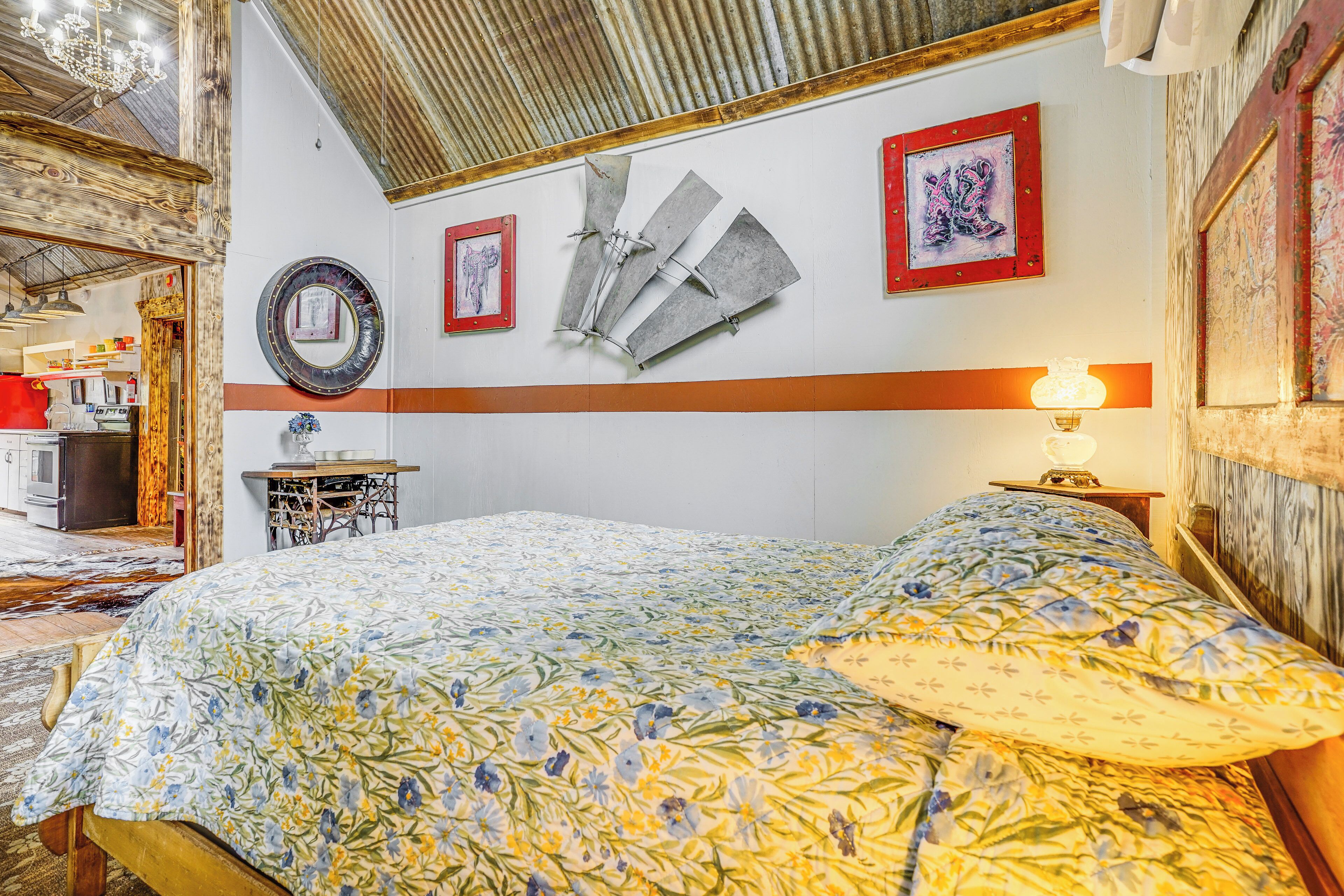 Une chambre à coucher avec un lit, un miroir fixé au mur et une œuvre d’art encadrée.