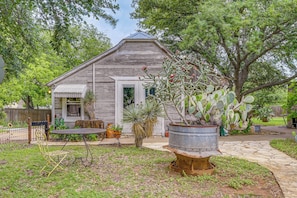 A rustic wooden house with a porch, a patio table, and chairs.