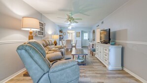 A living room with a sofa, a coffee table, a TV, and a ceiling fan. - Relaxing Nature Coast Condo Near Crystal River (Hernando)