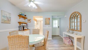 A dining area with wicker chairs, a glass table, and a ceiling fan. - Relaxing Nature Coast Condo Near Crystal River (Hernando)