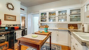 Una cocina con armarios blancos, una mesa de madera y un microondas.