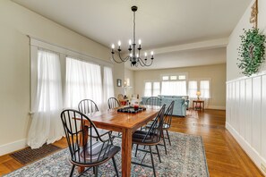 A dining area with a wooden table, chairs, a chandelier, and a patterned rug. - Steps to Main St! Restored Sonora Bungalow w/ Yard (Sonora)