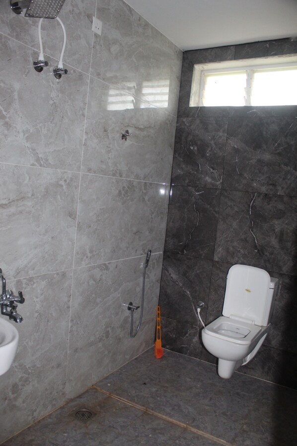 A bathroom with a shower, toilet, and sink.