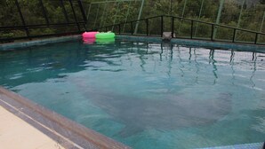 Una piscina con agua cristalina, borde de azulejos y una valla de seguridad.