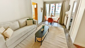 Una sala de estar con sofá, una mesa de centro y un comedor con sillas y una mesa.