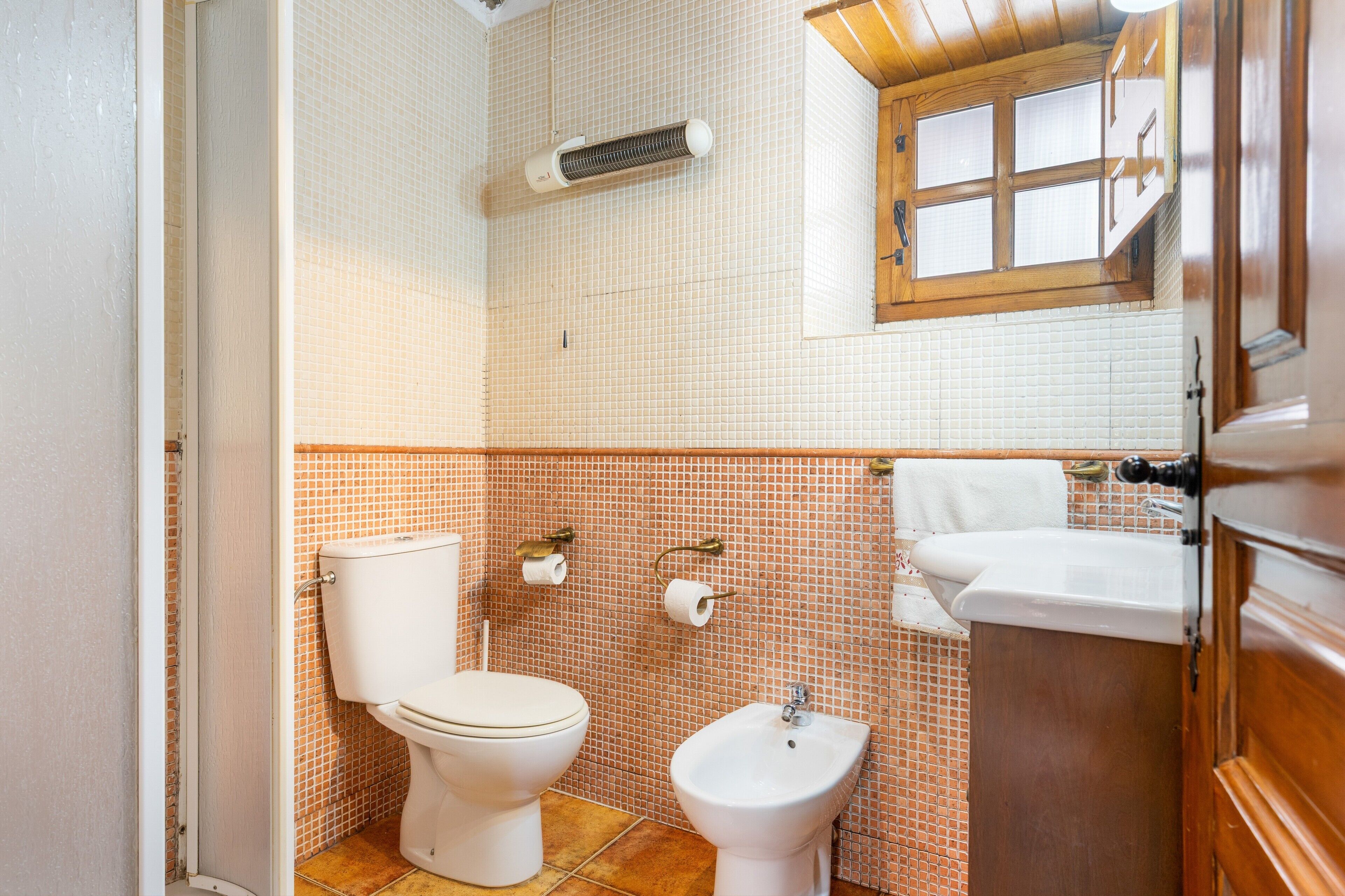 A bathroom with a toilet, bidet, and sink.
